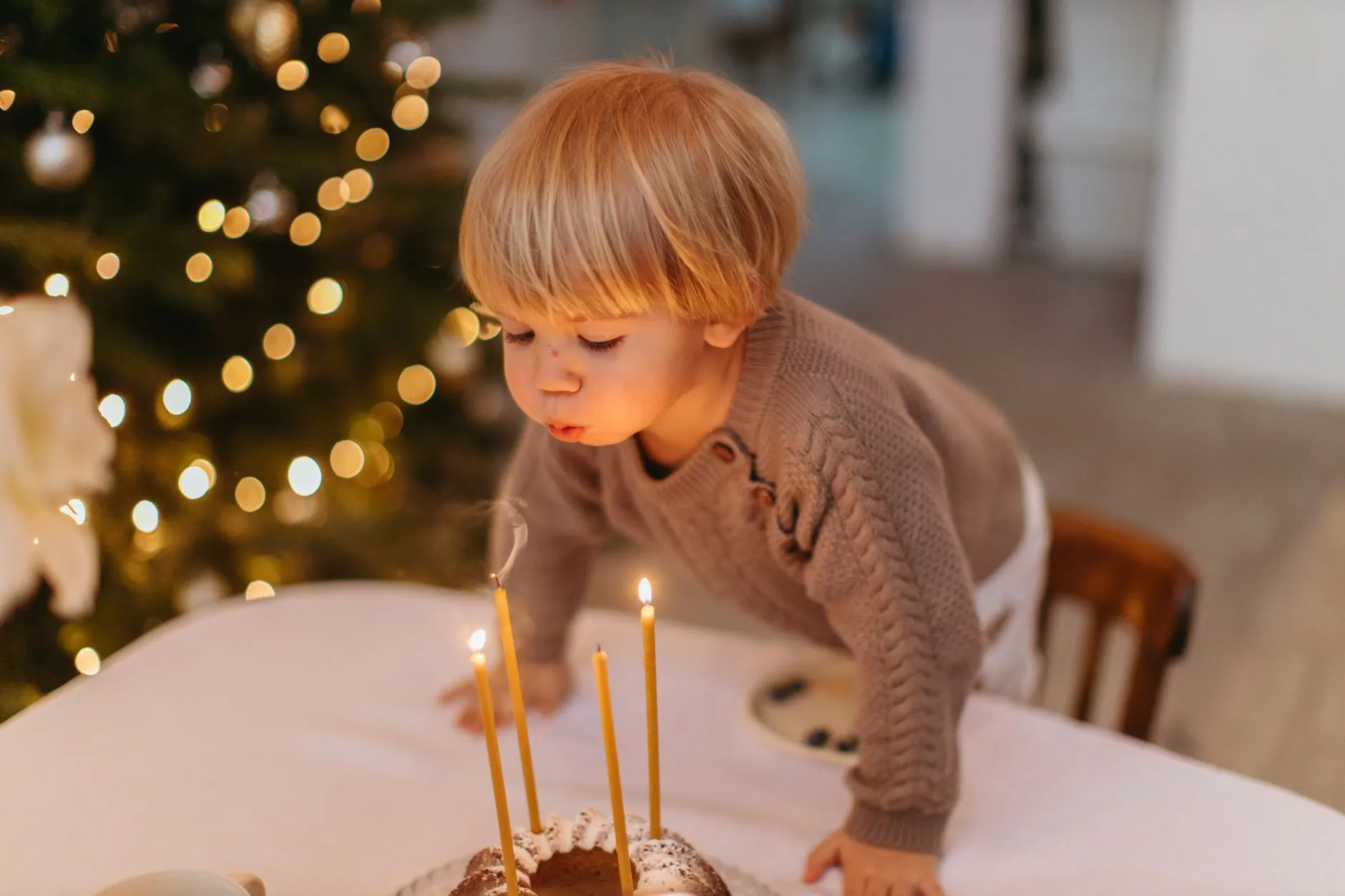 Niño soplando las velitas de su pastel de cumpleaños