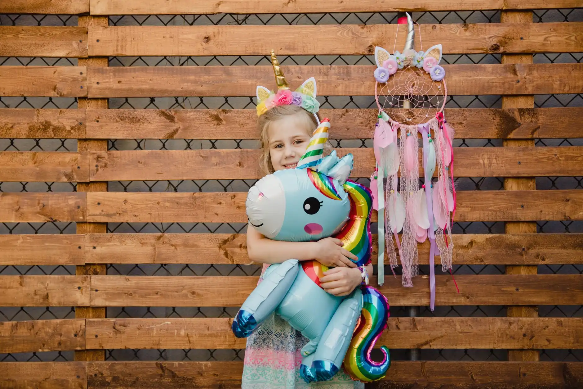 Niña posando con globo de unicornio
